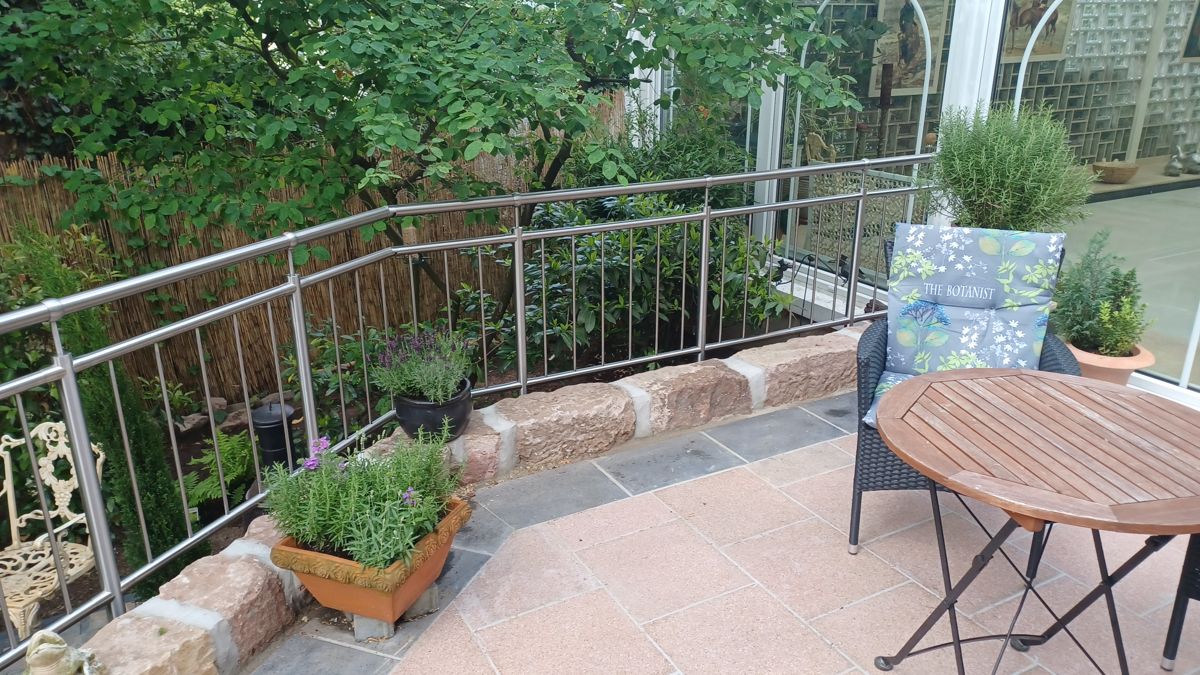 Ein Metallgeländer für eine Terrasse, gebaut auf Naturstein.