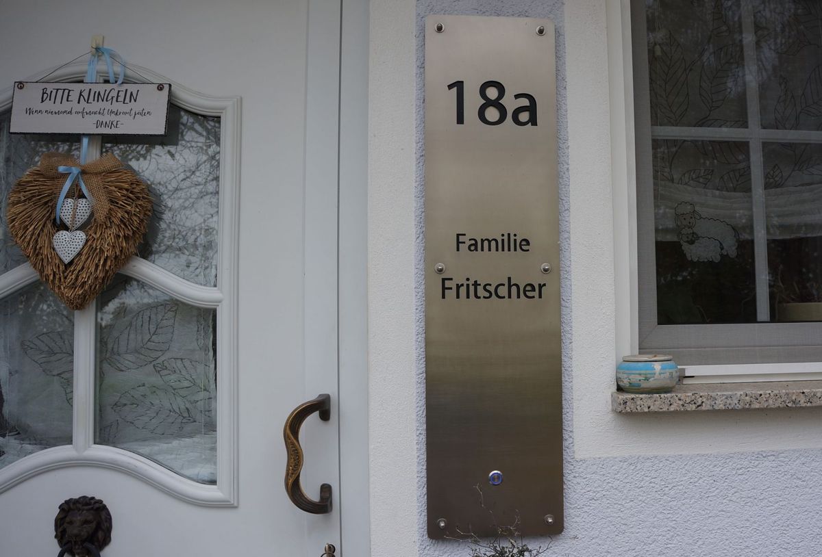 Ein aus Metall gefertigtes, großes Klingelschild mit integrierter beleuchteter Klingel.